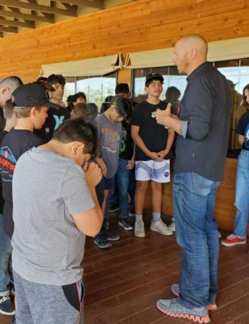 middle school students and teacher during a prayer